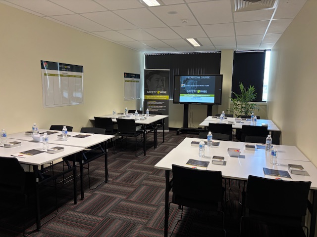 The Green Room laid out for training, with clustered tables facing a wall-mounted screen